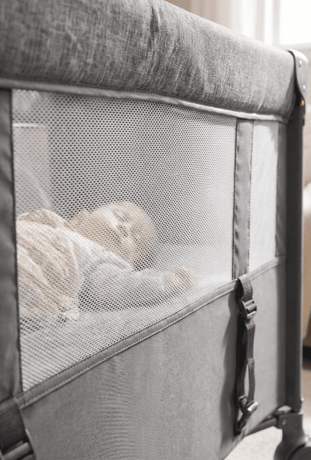 Bassinet Buying Guide (2026): The Safest Options for Newborn Sleep 1 Close-up view of the breathable mesh fabric on the side of the Adovel baby bassinet showing a sleeping baby inside.