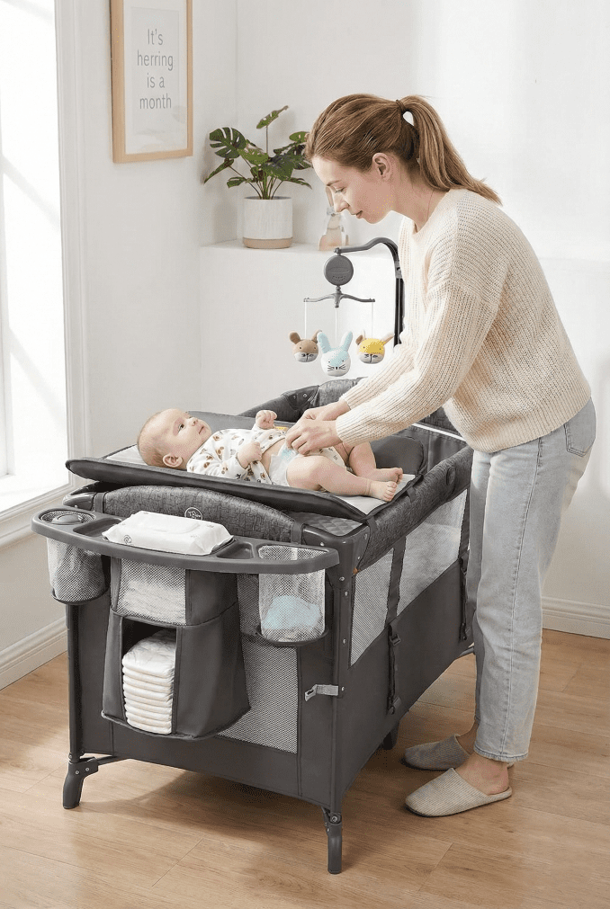 The Adovel baby bassinet featuring the attachable diaper changer station and side storage organizer stocked with baby supplies.