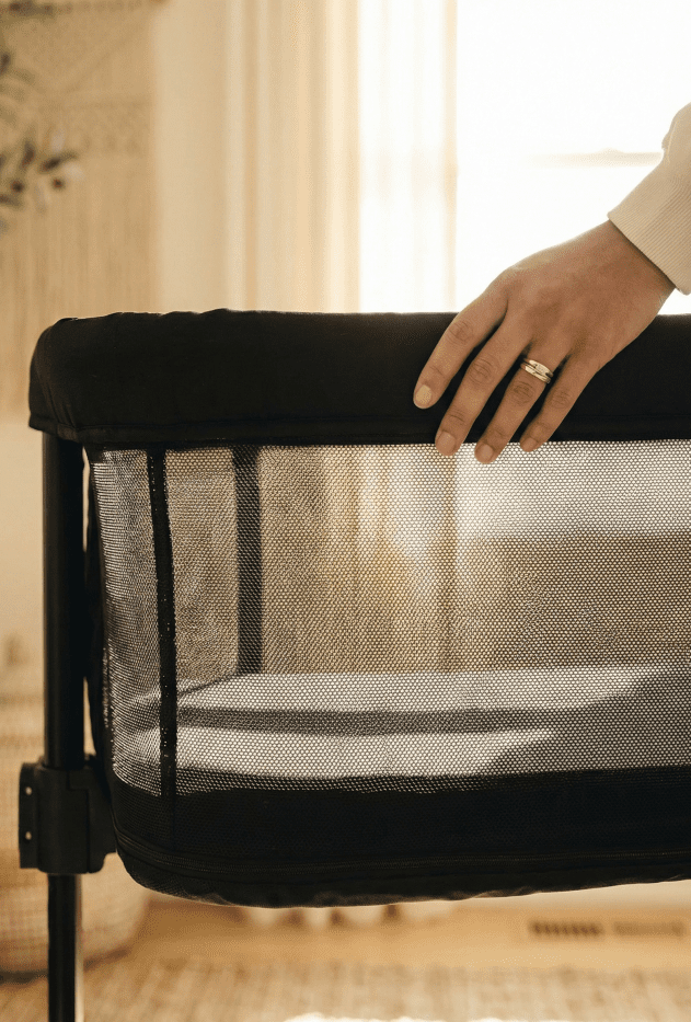 KoolerThings 3 in 1 Bassinet Review: A Safe Budget Pick? 3 Close-up detail showing sunlight passing through the breathable mesh sides of the KoolerThings bedside sleeper, emphasizing safe sleep design.